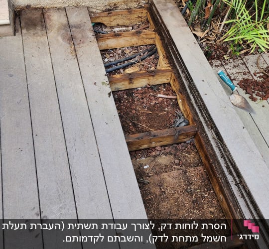 קרשים מעץ בגינה עם כלי עבודה ואדמה חשופה